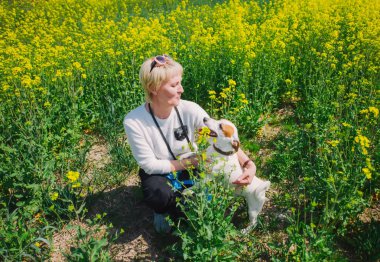 Beyaz kadın otonun içinde köpeğiyle oynuyor