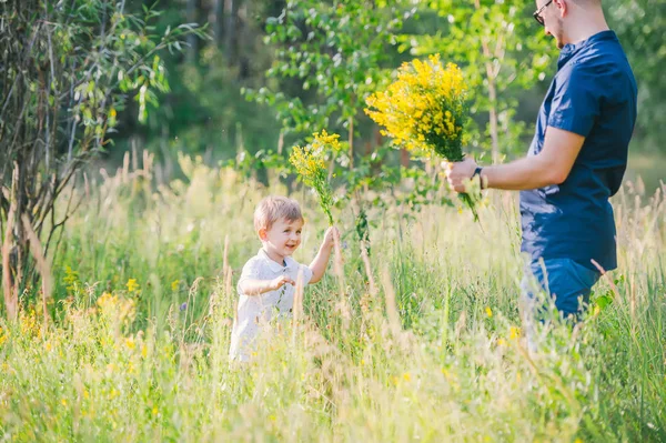 Little boy and his father enjoying outdoors in field of wildflowers — Stock Photo, Image