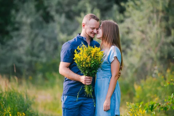 Kärleksparet på naturen med en bukett vilda gula blommor. Närbild porträtt — Stockfoto