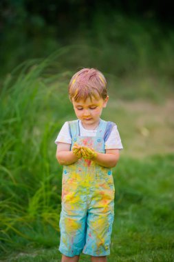 Boyalı küçük çocuk ellerini lekeledi.