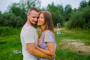 Çok renkli boyalar çift yaz çayırsarılma. Küçük oğulları arka planda..