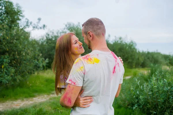 Coppia romantica in vernici multicolori che si abbracciano nel prato estivo . — Foto Stock