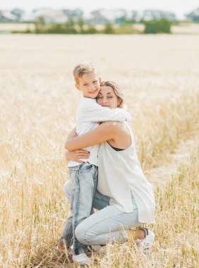 Anne sarılma ve buğday tarlasında onun küçük oğlu sevgi dolu.