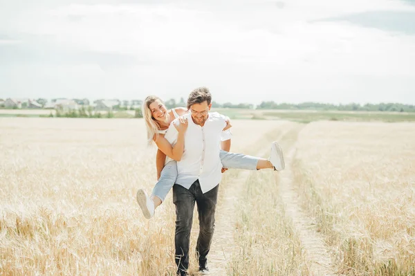 Feliz joven pareja disfrutando en el campo de trigo . —  Fotos de Stock