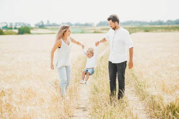 Cute little girl on walk with parent in wheat field on sunny day. Family vacation concept with copy space — Stock Photo, Image