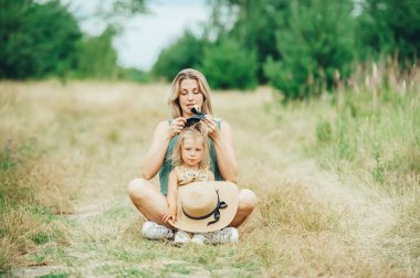 Güzel anne ve küçük kızı nilüfer çim en si poz oturup