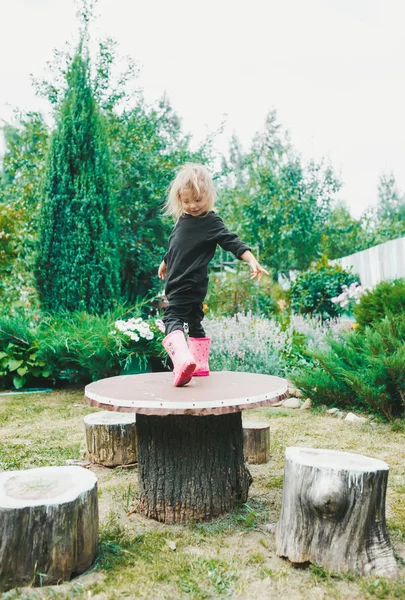 Cute Little Girl tańce na tle zielonego ogrodu — Zdjęcie stockowe