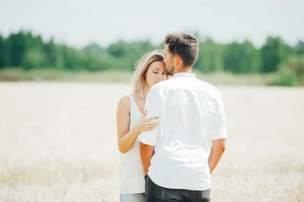 Vista posterior primer plano retrato de linda pareja amorosa de pie posando en el campo de trigo . —  Fotos de Stock