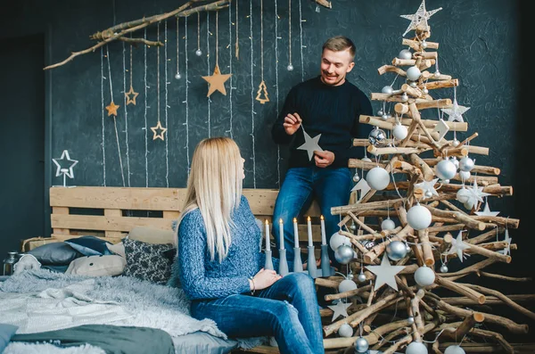 Feliz pareja decorando árbol de Navidad en el dormitorio en casa . —  Fotos de Stock