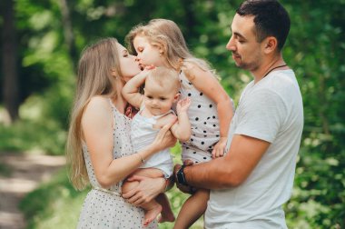 Açık havada duran iki kızı ile mutlu bir aile portresi