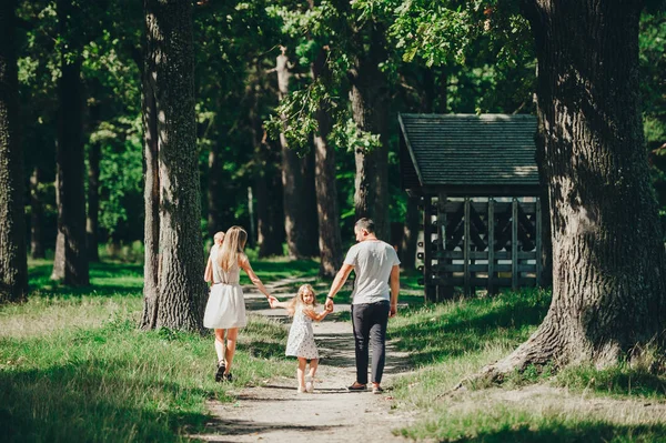 Gelukkige familie met twee kinderen hebben rust op een wandeling buitenshuis. — Stockfoto