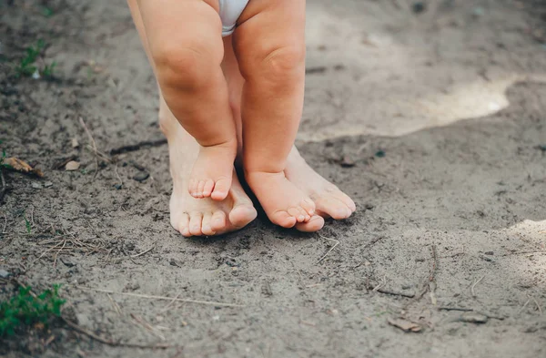 Mujer y su pequeño hijo de pie en el suelo al aire libre. Primer plano. . — Foto de Stock