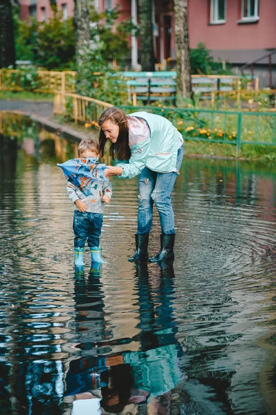 Mom helps reveal umbrella to her little son. — Stock Photo, Image