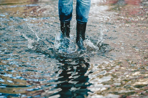 站在夏季水坑中穿着橡胶靴的妇女的腿 — 图库照片