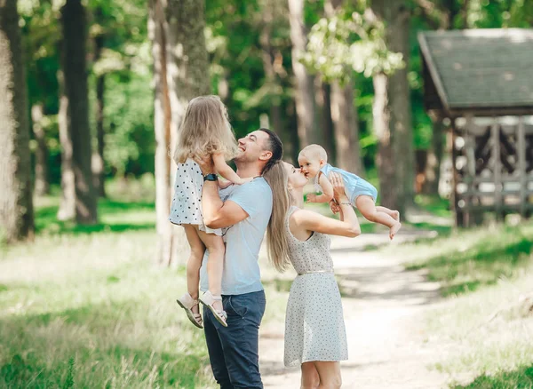 Lycklig familj spenderar tid tillsammans i naturen. Föräldrar med barn har roligt och njuter av att vara tillsammans. — Stockfoto