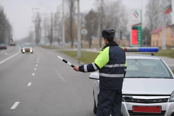 Oficial de policía de la Inspección Estatal de Automóviles controla el tráfico en la calle de la ciudad — Foto de Stock