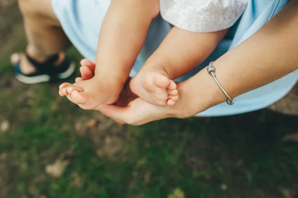 Mother holding tiny feet of newborn baby. Closeup — Stock Photo, Image