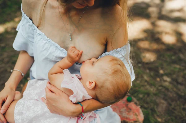 Η μητέρα θηλάζει αξιολάτρευτο μωρό παιδιά outdors. Κλείσιμο. — Φωτογραφία Αρχείου
