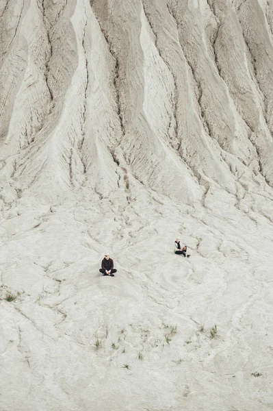Mężczyzna i kobieta siedzi na piasku w odległości w kamieniołomie wapiennej w Rummu. Estonia — Zdjęcie stockowe