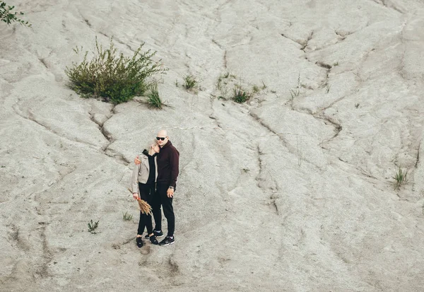 Młoda kochająca para stoi na białym piasku geologicznej i przemysłowej dzielnicy w Rummu. Estonia. — Zdjęcie stockowe