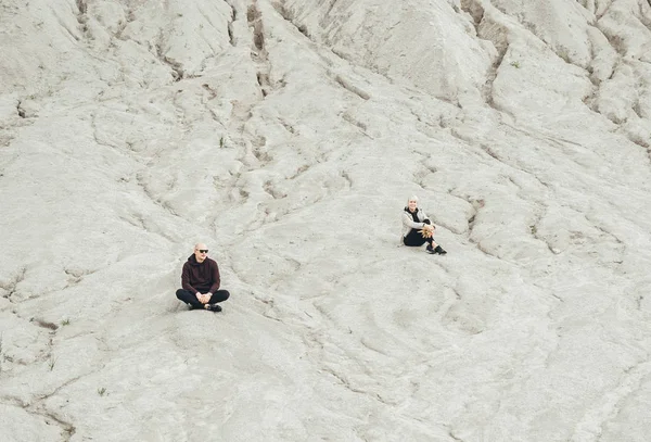 Młoda para robi ćwiczenia jogi siedząc na piasku na zewnątrz. — Zdjęcie stockowe