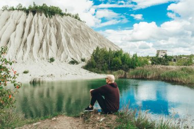Siyah gözlükgenç kel adam gölün kıyısında doğanın güzelliği zevk