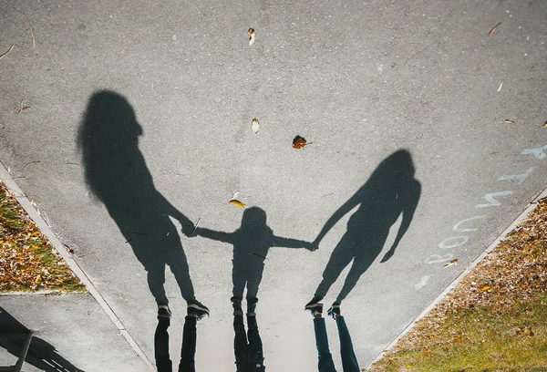 Ombre di una famiglia con bambino sulla strada asfaltata con aut — Foto Stock