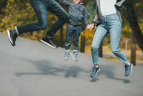 Fröhlich fröhliche Familie springen auf Landstraße im Herbst. Nahaufnahme. — Stockfoto