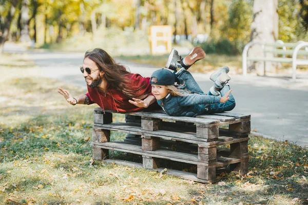 Padre e hijo haciendo ejercicios de yoga juntos en el parque de otoño . — Foto de Stock