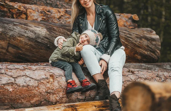 Höstporträtt av mor och liten flicka i höstskogen på stubbe av stockar. — Stockfoto