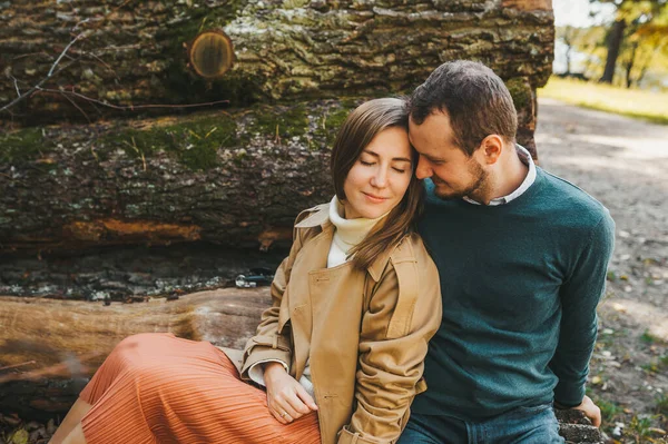 Una coppia adorabile seduta sui tronchi abbattuti nella foresta. Un abbraccio tra uomo e donna. storia d'amore . — Foto Stock