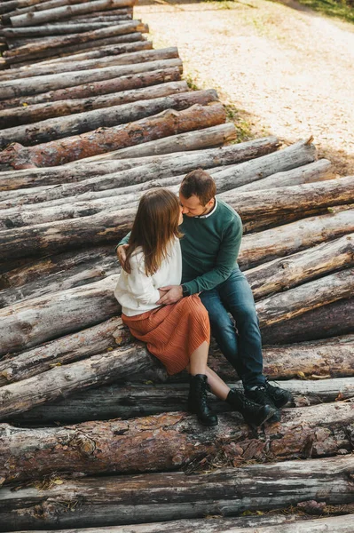 Ett par förälskade som omfamnar de fällda stockarna i skogen. Man och kvinna omfamnar. — Stockfoto