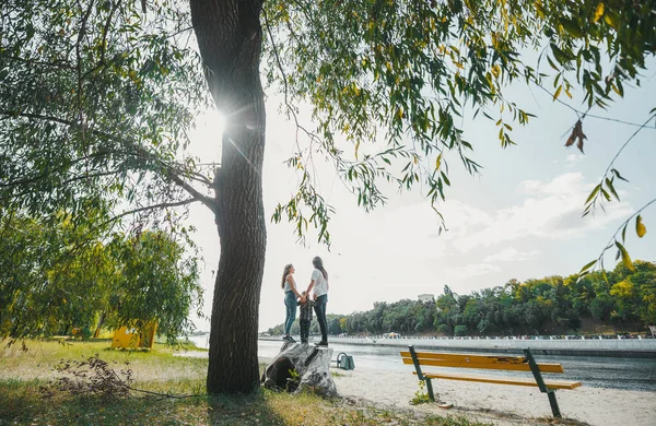 Mutlu ebeveynler ve küçük oğlu güneşli bir sonbahar gününde nehir kenarında dinleniyorlar.. 