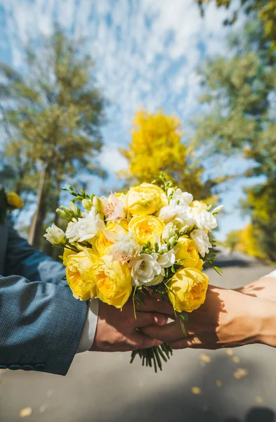 Bouquet da sposa di rose gialle su uno sfondo di alberi autunnali e cielo blu nella giornata di sole — Foto Stock