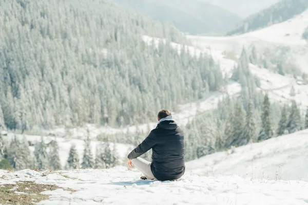 Jeune homme assis et profitant de la vue sur la montagne dans les Carpates. Vue arrière . — Photo