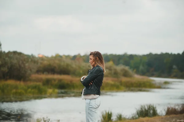 秋天的一天，站在河边享受和放松的白人妇女 — 图库照片
