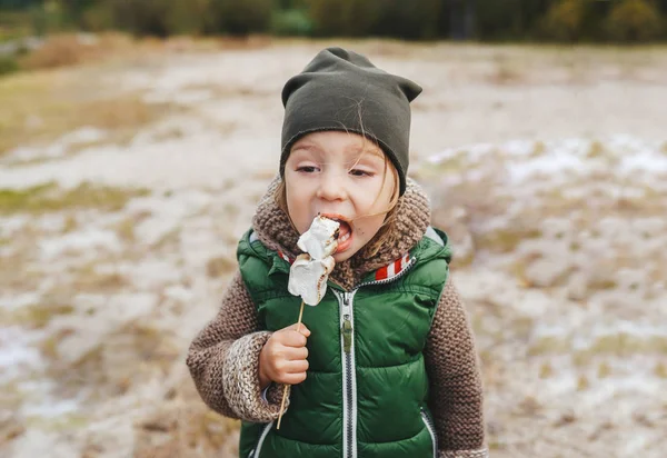 Holčička jí pečený marshmallow u vlastního táboráku. Zábavný rodinný koncept. — Stock fotografie