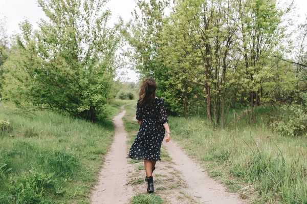 Piękna Brunetka Czarnej Sukience Odchodzi Zielonej Trawie Polu Natura Wiosnę — Zdjęcie stockowe