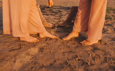 Bir yaz günü, aynanın yansımasında nehrin yanındaki kumun üzerinde iki kadın bacağı durur. Ayna ile kavramsal fotoğraf. Yakın çekim.