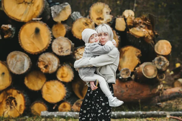 Boldog Anya Kislánya Pózolnak Háttérben Halmozott Rönkök Egy Őszi Erdőben — Stock Fotó