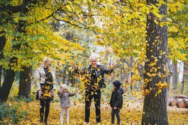 Sonbahar parkında dört kişilik aile portresi. Mutluluk konsepti, zevk zamanı.