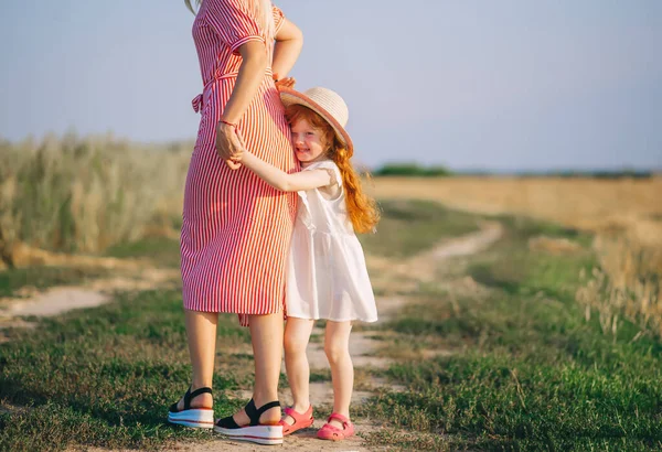 Όμορφη Νεαρή Μητέρα Κόκκινο Φόρεμα Κοκκινομάλλα Κόρη Ψάθινο Καπέλο Αγκαλιάζει — Φωτογραφία Αρχείου