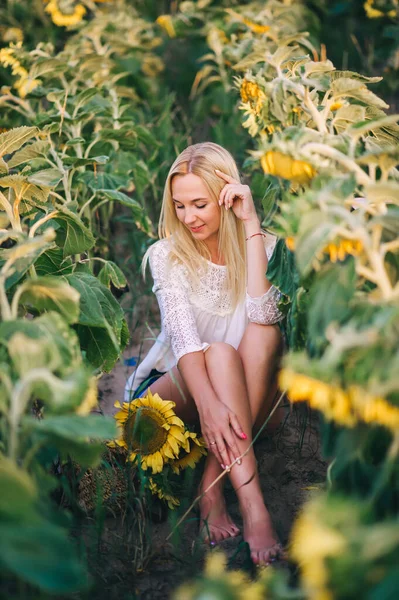 Portret Młodej Blondynki Białej Bluzce Siedzącej Tle Słoneczników Zbliżenie — Zdjęcie stockowe