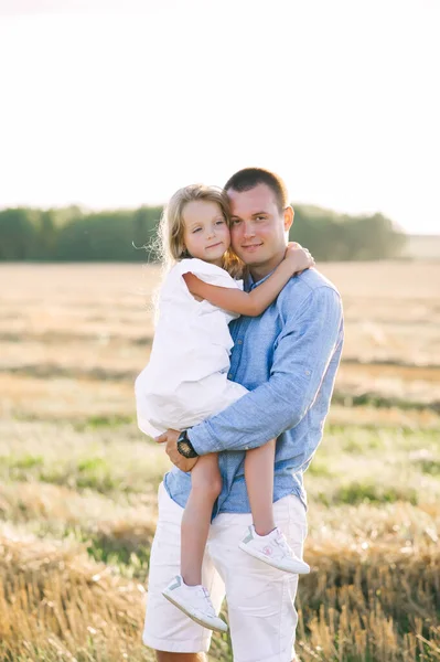 父は夏に畑で娘を抱きかかえて立っている 幸せな父親の日 縦の肖像 — ストック写真
