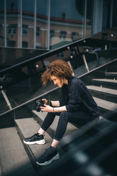 Mujer Fotógrafa Sosteniendo Cámara Digital Mientras Está Sentada Escalera Cerca — Foto de Stock