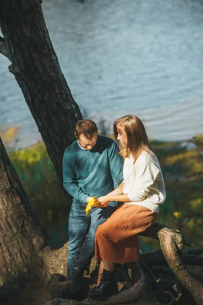 在美丽的秋天的森林里 一对恋人正坐在湖上的圆木上 — 图库照片