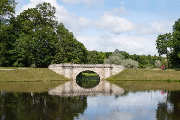 Taş köprü parkta bir yaz günü suya yansıdı.