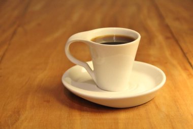 Ahşap arka planda bir fincan dolusu kahve manzarası