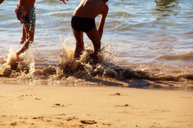 Kumsalda futbol oynayan insanların bacaklarına bakın. 