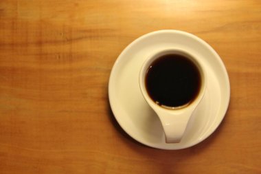 Ahşap arka planda bir fincan dolusu kahve manzarası